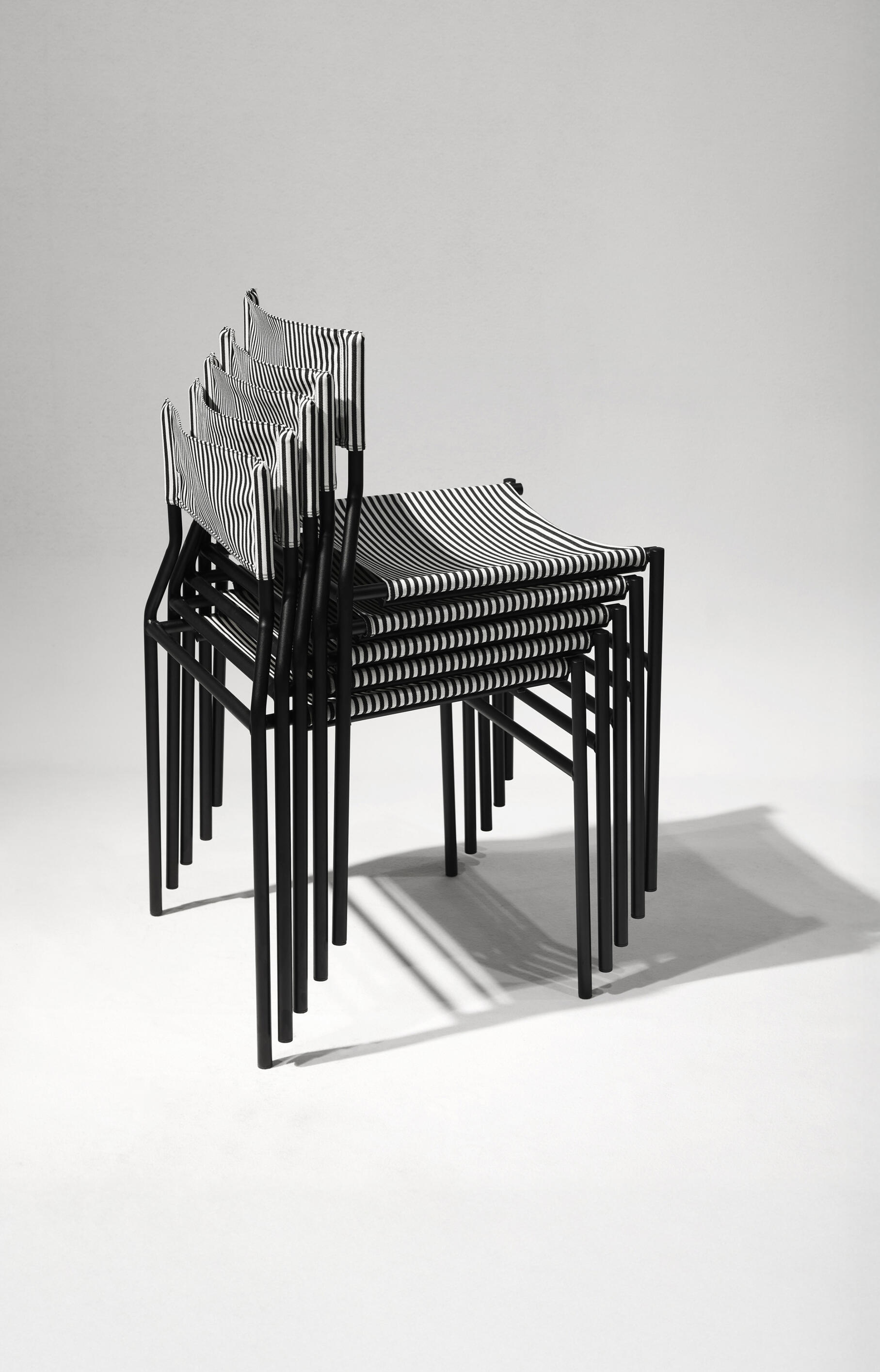 Stackable contemporary chairs designed for efficient series production, integrating innovative manufacturing, material efficiency, and sustainable product design.